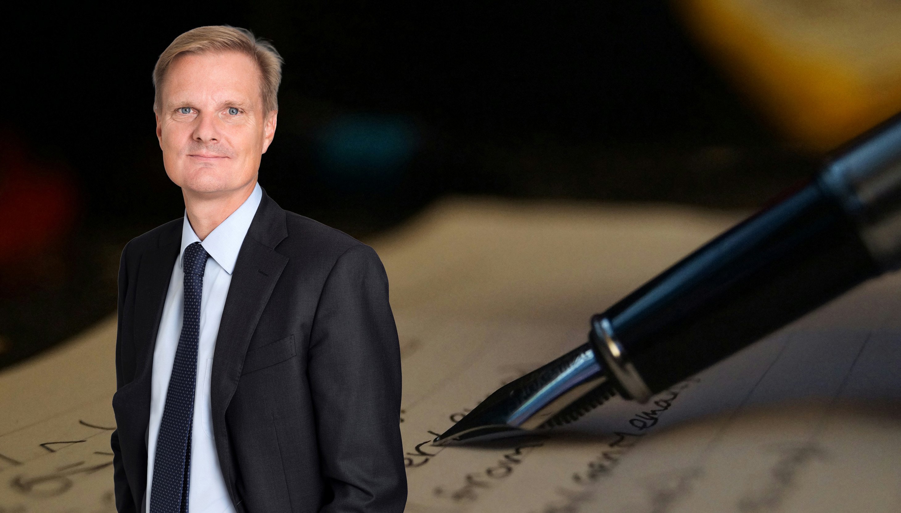 Jens Henriksson in front of pen and paper with writing