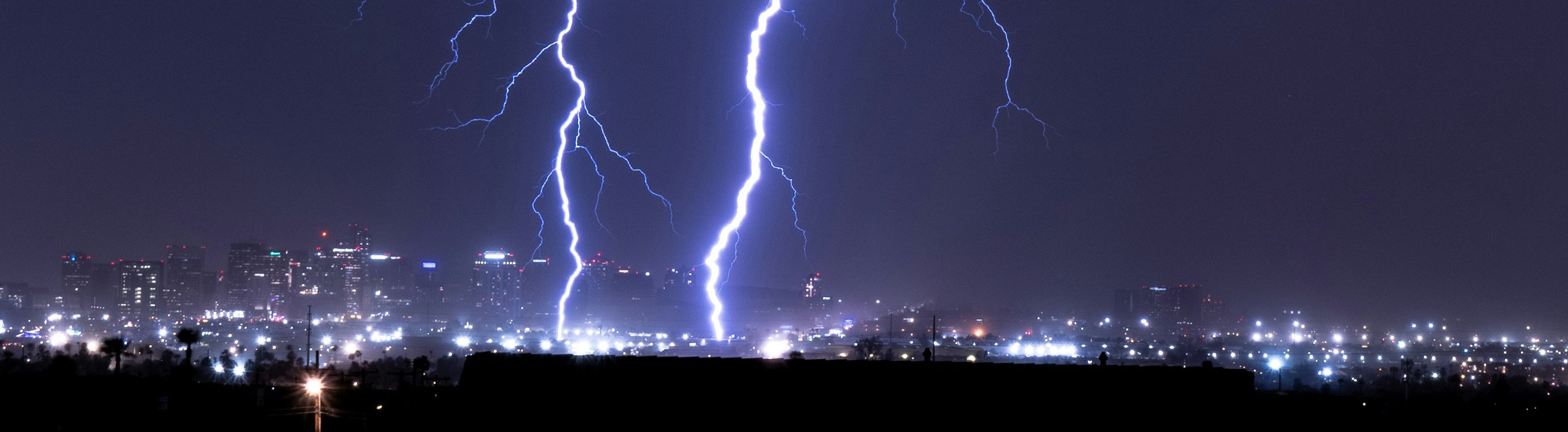 blixnedslag över nattupplyst stad