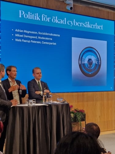 Politikerpanel på scen på IVA mot bakgrundsbild Politik för ökad cybersäkerhet