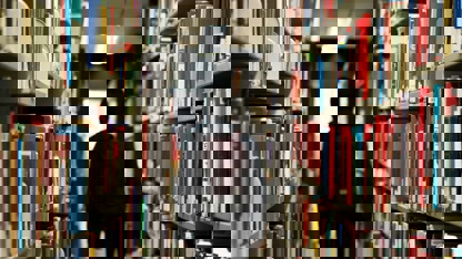 Person med ryggsäck mellan bokhyllor