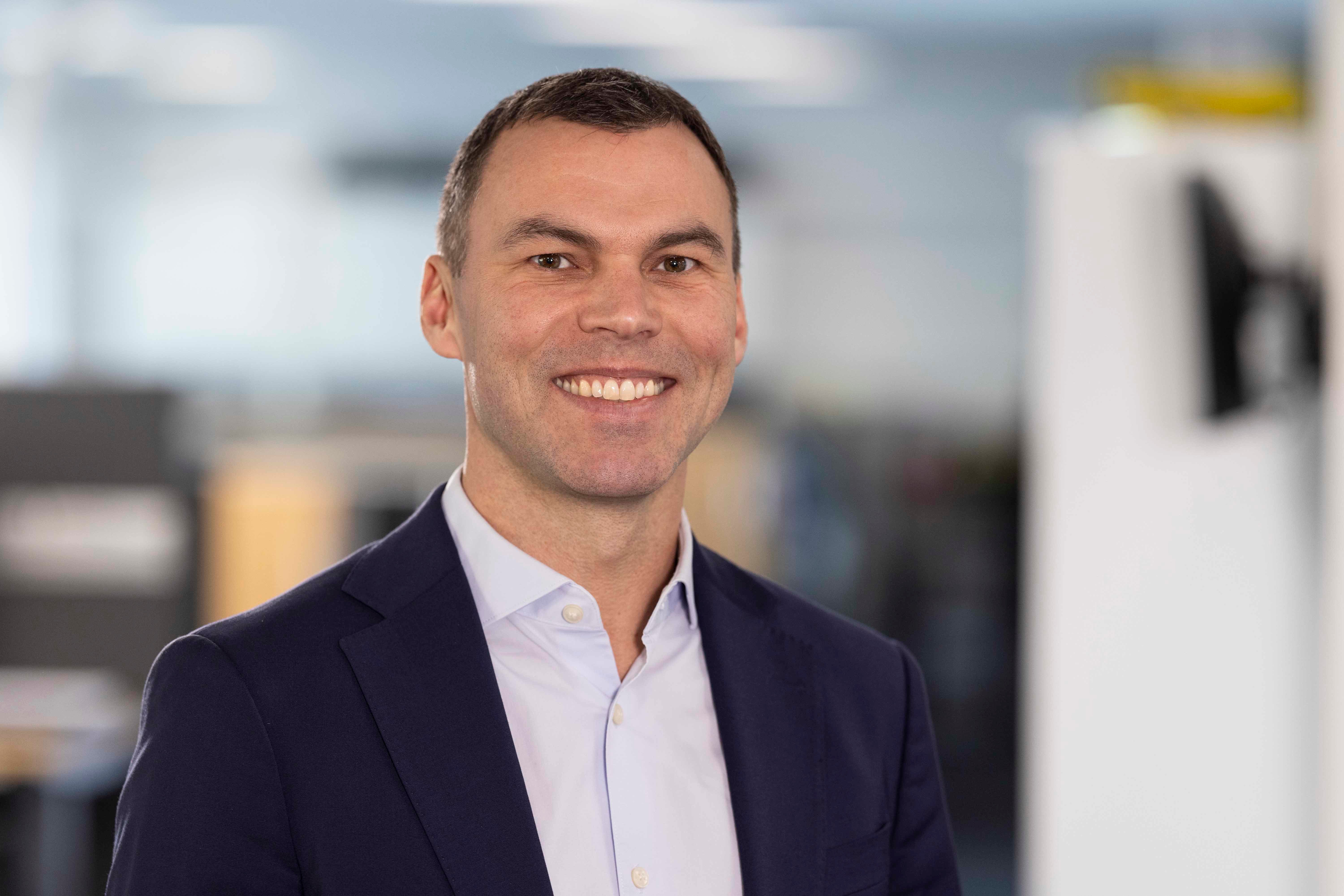 Leende Wandt i vit skjorta och kavaj