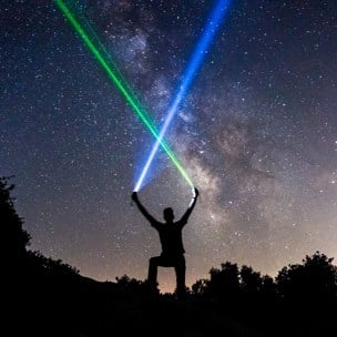 korsande laserstrålar mot natthimmel
