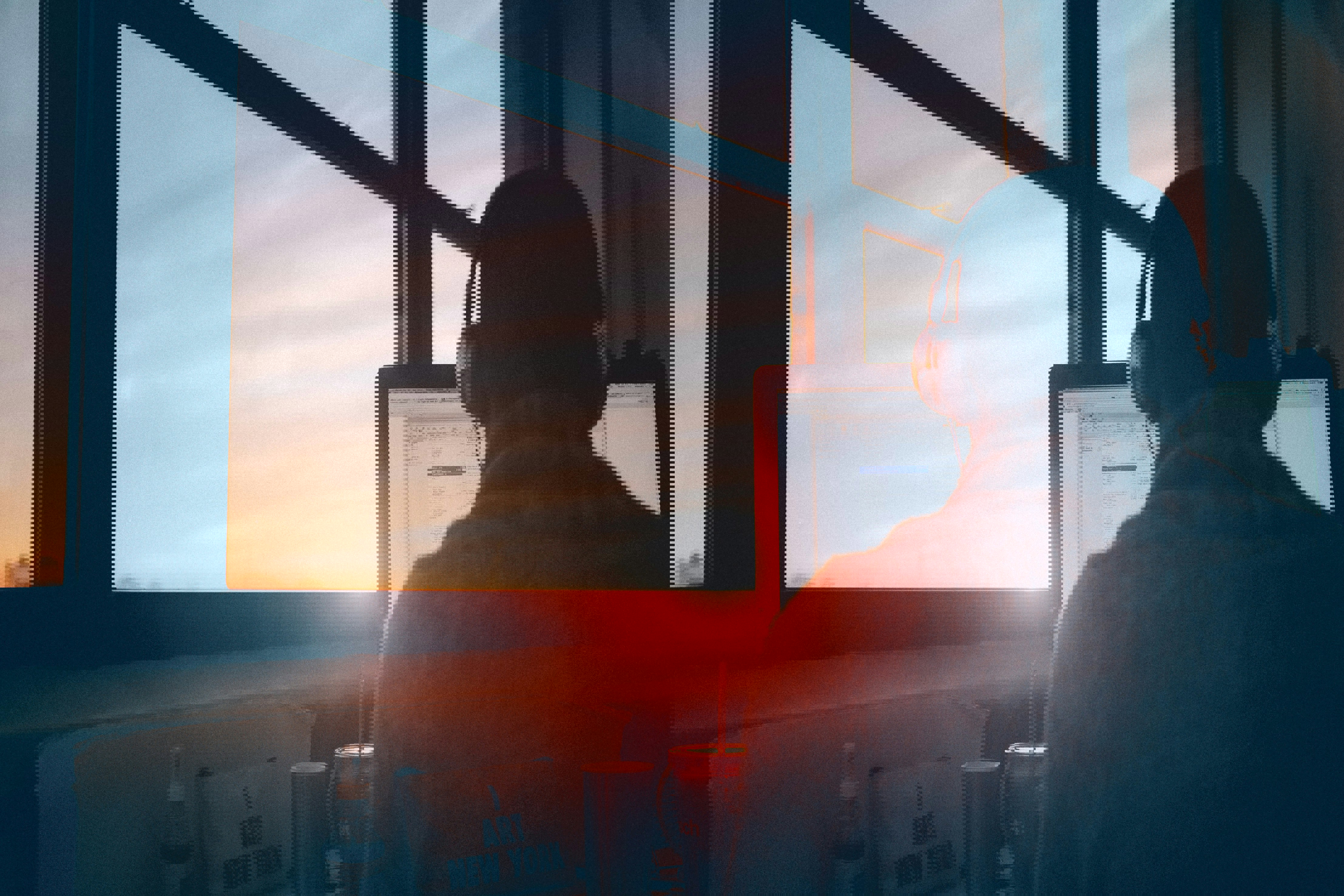 person framför datorskärm vid fönster