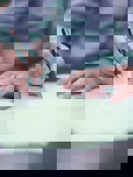 närbild person fyller i formulär med papper och penna