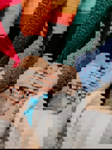 Framsträckta händer håller varandra