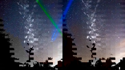 Person Crossing Laser Beams Into Sky