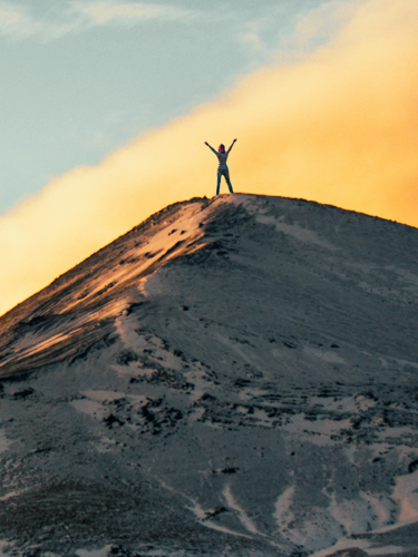 Hand med målad röd blixt mot rosa bakgrund