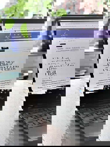 Uppfälld bärbar dator på ett bord vid ett fönster