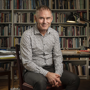 Sverker Sörlin med bokhylla i bakgrunden